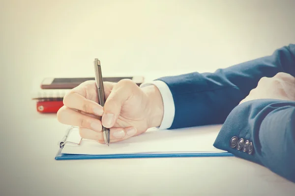 Closeup of Businessman writing on paper on notepad — Stock Photo, Image