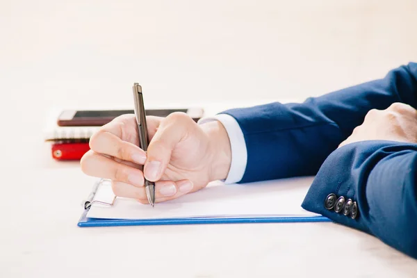 Closeup of Businessman writing on paper on notepad — Stock Photo, Image