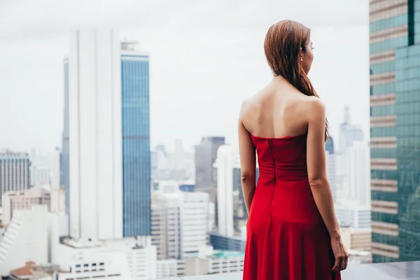 都市の屋上から見ているドレスを着た美しい女性 — ストック写真