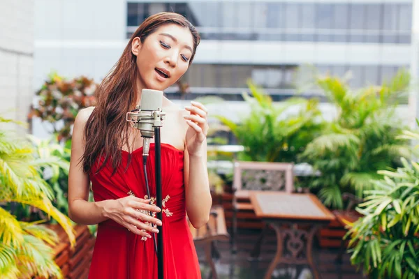 Mujer asiática cantando en la azotea del edificio en escena al aire libre —  Fotos de Stock