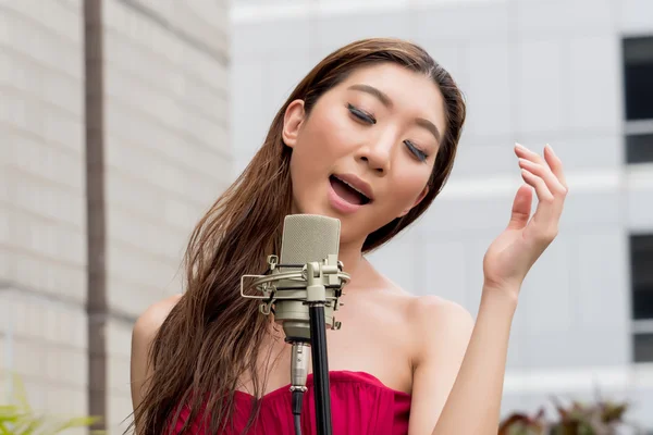 Mujer asiática cantando en la azotea del edificio en escena al aire libre —  Fotos de Stock