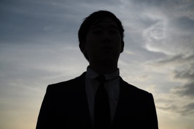 Açık iş adamı olarak siluet günbatımı arka plan ile karşı karşıya