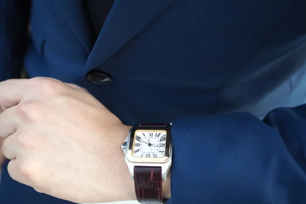 Biznesmen w elegancki garnitur niebieski patrząc na luksusowy zegarek oczekiwania — Zdjęcie stockowe