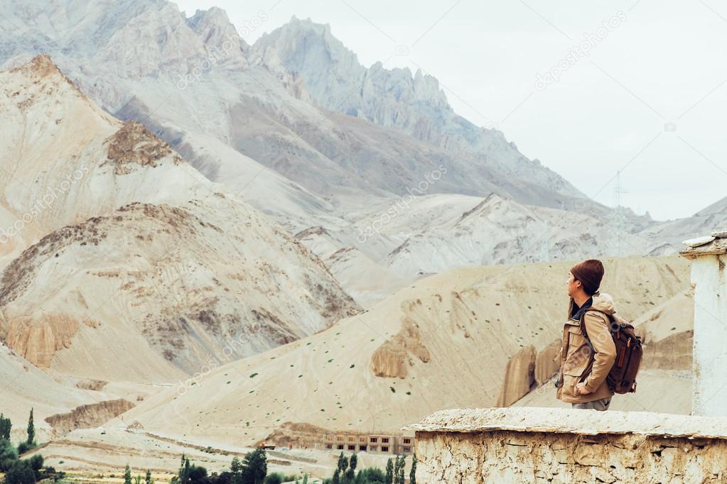 Young male traveler standing on the sand cliff, thinking about or looking forward to something in Leh, Ladakh,India .