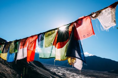 Colorful prayer flags with sun shining through one of prayer flags in Leh, Ladakh, India clipart