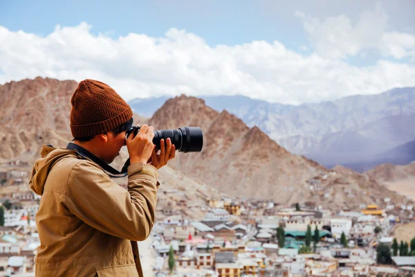 Close-up of travel photographer journalist holding a dslr camera in mountain background — Stock Photo, Image