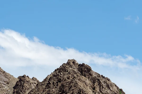 Top of rock mountain in blue cloud sky - with copyspace in Leh, Ladakh, India. — Stock Photo, Image
