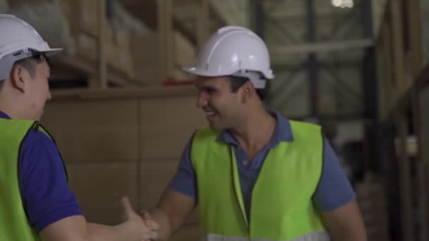 20s šťastný indické distribuce skladiště pracovník potřást rukou s asijskými spolupracovníky ve skladu lodní společnosti. Obchodní spolupráce a koncepce týmové práce — Stock video