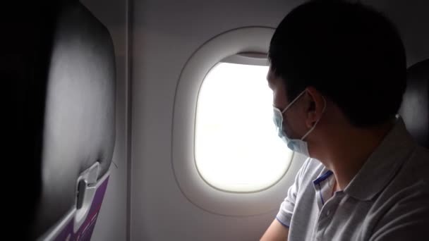 Młody, dorosły, azjatycki turysta w masce na twarz w kabinie samolotu. Transport publiczny podczas pandemii Covid-19 lub Coronavirus. Nowa normalna koncepcja podróży — Wideo stockowe