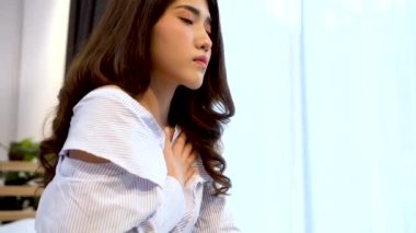 Geceleri yatak odasında nefes almakta zorlanan 20 'li yaşlardaki Asyalı genç bir kadının portresi. Nefes darlığı, astım, nefes almakta zorlanıyorum. Corona Virüsü belirtileri