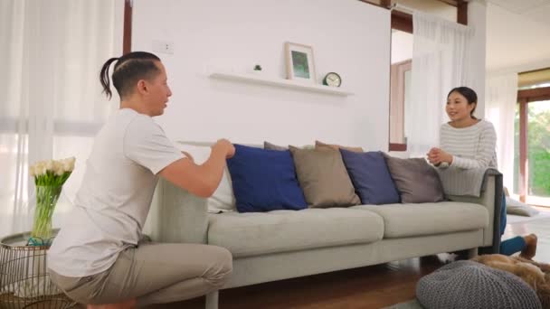 Ein junges Paar trägt gemeinsam ein modernes Sofa. Millennial-Familie bezieht neue Möbel in neues Zuhause. Möblierung und Renovierung des neuen Hauses — Stockvideo