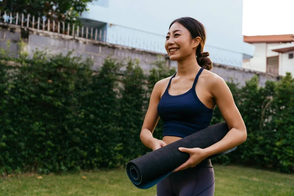 Glückliche asiatische Yoga-Trainerin im Garten — Stockfoto