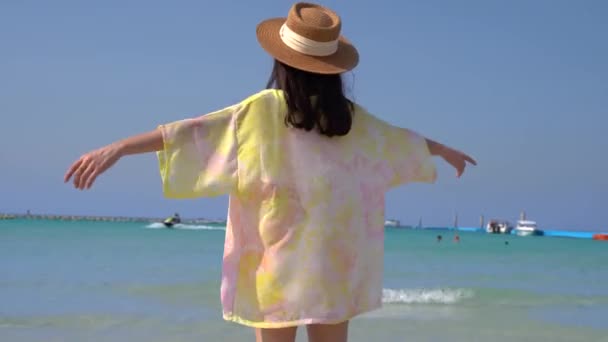 Jeune femme jouant des éclaboussures d'eau dans l'océan de plage tropicale. Belle fille sexy ludique avec les bras ouverts dans la mer pendant les vacances de voyage — Video