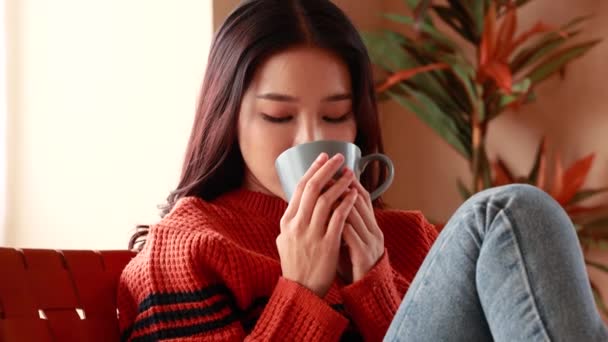 Mulher asiática desfrutando de bebida quente em casa — Vídeo de Stock
