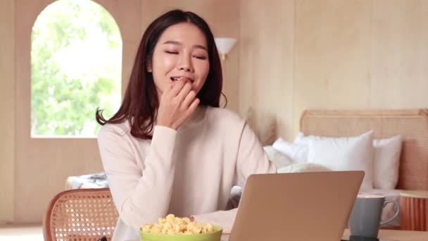 若い十代のアジアの女性はベッドルームでかなり笑顔でセーターを着ています。映画、映画、ビデオをオンラインで見てノートパソコンを使用して幸せな笑顔の女の子。オンライン技術の概念. — ストック動画