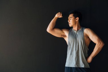 Stüdyoda pazılarını sergileyen odaklanmış genç etnik sporcu.