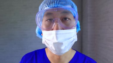 Pediatri üniformalı ve yüz maskesi takan Asyalı bir sağlık görevlisi Covid-19 hastalarını teşhis ve muayene ediyor. Genç hemşire Corona virüsü enfeksiyonu için genizden örnek alıyor.