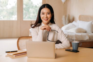 Evde çalışan gözlüklü zeki etnik kadın.