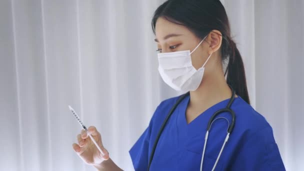 Κοντινό πλάνο της γυναίκας Ασιάτισσας νοσοκόμας που κρατάει μια βελόνα ένεσης εμβολίου έτοιμη για εμβολιασμό. Νέος τεχνικός ιατρικού εργαστηρίου στην εργασία - 4k 60fps πλάνα — Αρχείο Βίντεο
