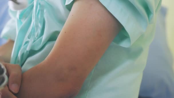 Zbliżenie rąk młodej lekarki wykonującej wstrzyknięcie szczepionki młodemu pacjentowi płci męskiej na ramionach w celu zapobiegania pandemii zakrzepowej-19 - materiał filmowy 4k 60fps. — Wideo stockowe