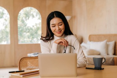 Evde çalışan gözlüklü zeki etnik kadın.