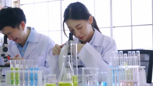Mujer con colega haciendo investigación médica en laboratorio — Vídeos de Stock
