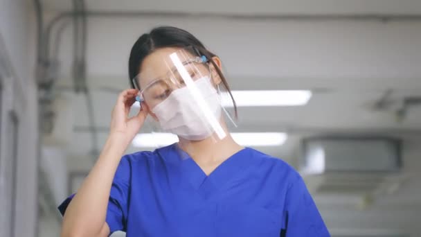 Young tired covid health worker removing face shield — Stok video