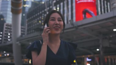 Mutlu kadın telefonda yürüyüp konuşuyor.