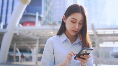 Akıllı telefon kullanan genç bir iş kadını