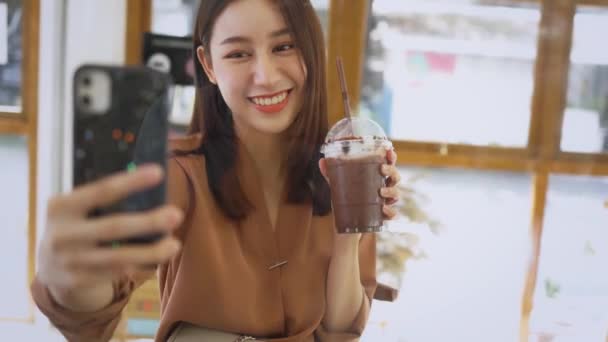 Mujer tomando selfie con bebida en la cafetería — Vídeo de stock