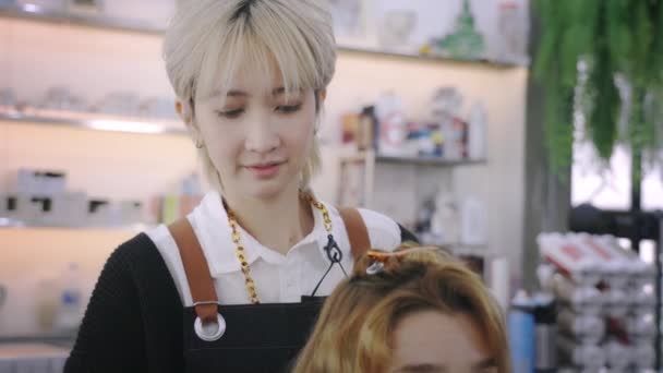 Glad kvinnlig frisör styling klient hår — Stockvideo