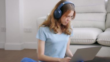 Akıllı telefon ve kulaklıklı laptop kullanan kız