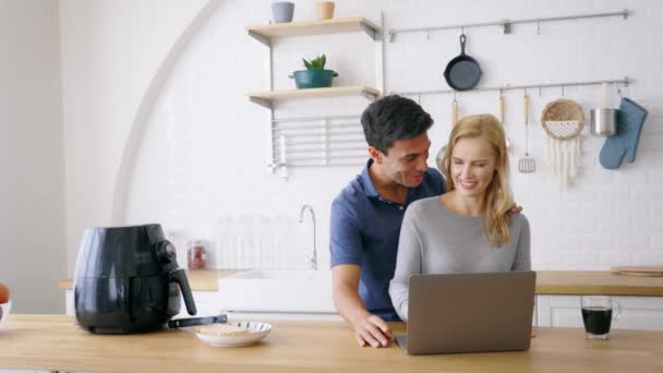 Casal usando laptop na cozinha — Vídeo de Stock