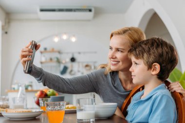 Annem kahvaltıda oğluyla selfie çekiyor.