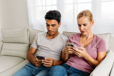 Çift akıllı telefon kullanarak birlikte oturuyor.