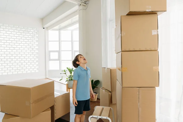 Boy looking at pile of cardboard boxes — Stock Photo, Image