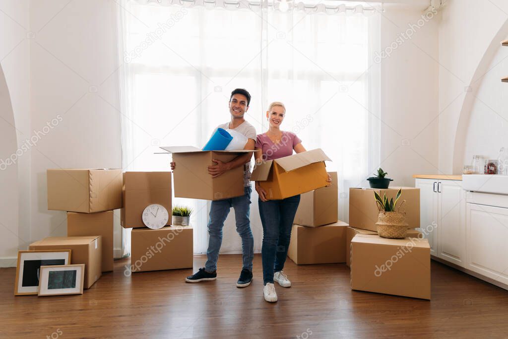 Couple holding cardboard box at home