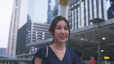 Genç iş kadını telefonla yürüyor.