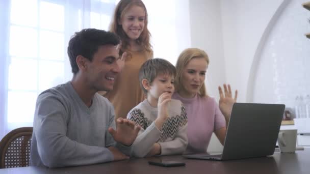 Νεαρή οικογένεια που χρησιμοποιεί φορητό υπολογιστή στο σπίτι — Αρχείο Βίντεο