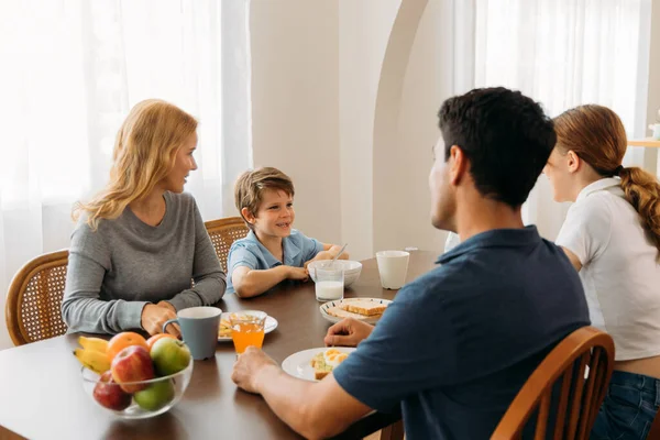 Família feliz falando enquanto desfruta do café da manhã — Fotografia de Stock