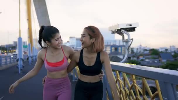 Jonge vrouwelijke atleten op de brug praten en lopen — Stockvideo