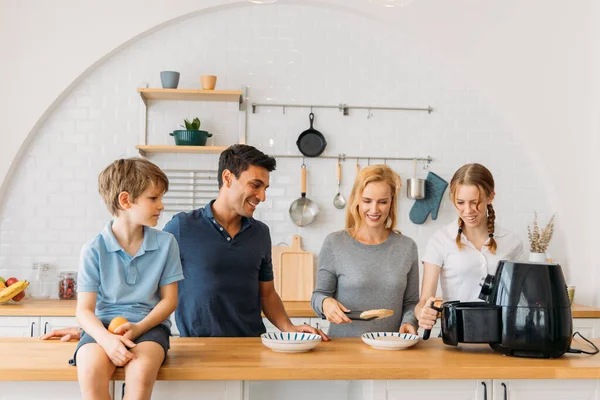 Glückliche Familie bereitet Snacks in der Fritteuse zu — Stockfoto