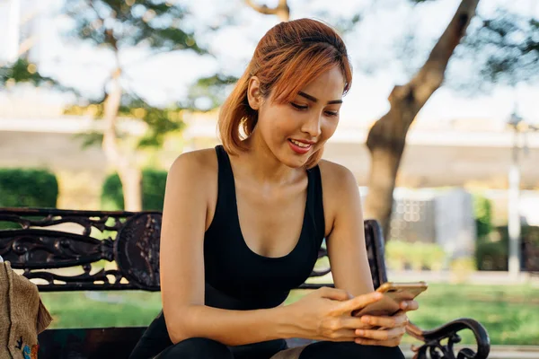 Woman checking phone during morning run — Stock Photo, Image