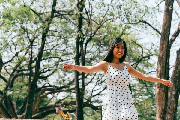 Feliz e despreocupado jovem 20s mulher dançando na floresta ao ar livre com árvores verdes — Fotografia de Stock