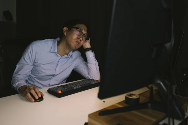 젊은 사업가는 회사 사무실에서 과로 하였다. 남자 사무직 근로자는 밤늦게 까지 시간외 근무를 하면서 생각하고 스트레스를 준다 — 스톡 사진