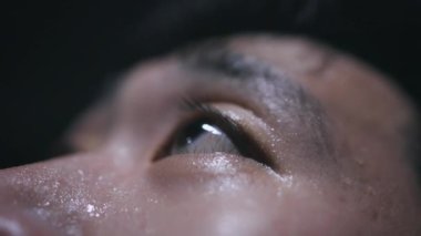 Aşırı yakın plan terli ve yorgun Asyalı erkek koşucu çok terliyor. Genç Çinli koşucu koşuya ara veriyor..