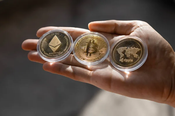 Joven sosteniendo Crypto fichas Bitcoin, Ethereum, Onda en la palma de la mano —  Fotos de Stock