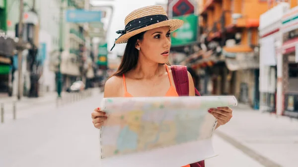 Junge hispanische Brünette schaut sich im Urlaub die Landkarte an — Stockfoto