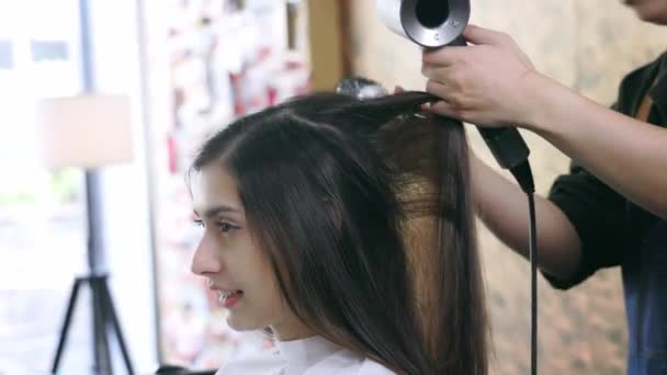 Κομμωτήριο χρησιμοποιώντας στεγνωτήρα μαλλιών για τον πελάτη — Αρχείο Βίντεο