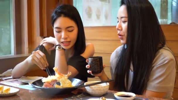 Two Asian female friends eating and having a meal together. Women enjoying good time at restaurant — Video